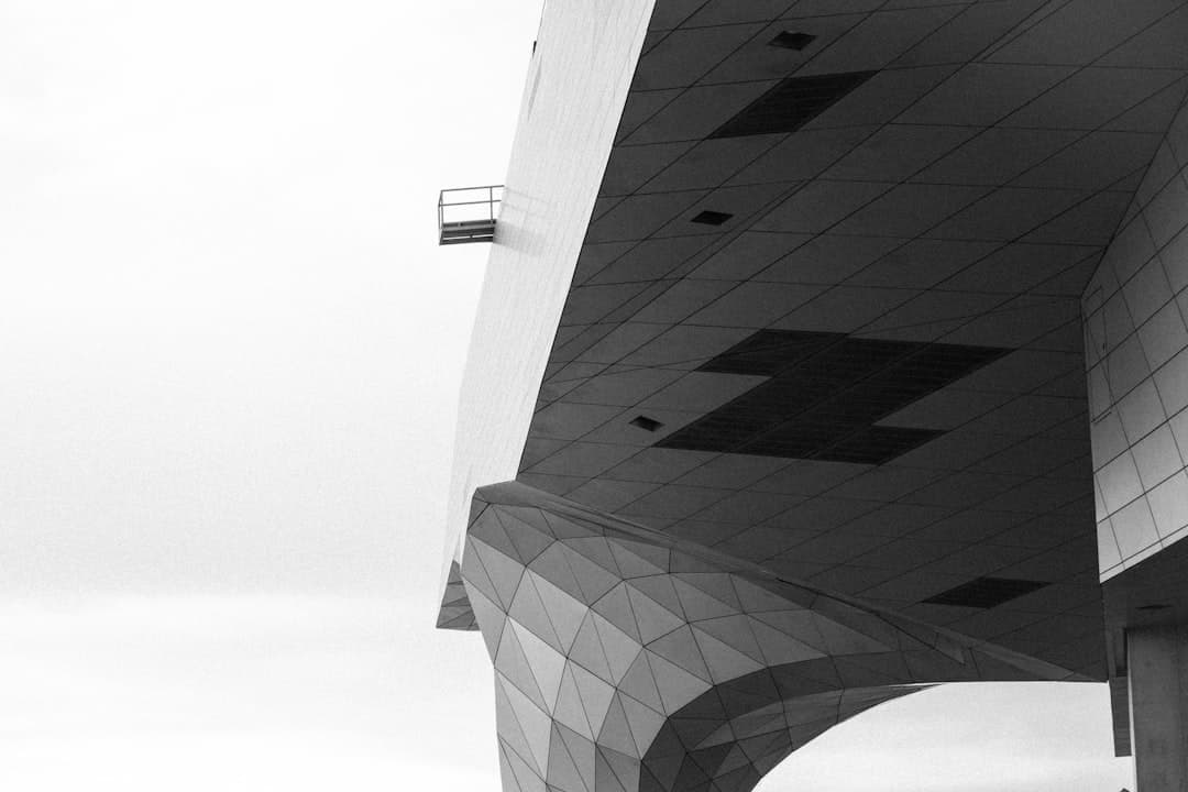 Bâtiment moderne en contre-plongée noir et blanc, illustrant la transformation architecturale d'un projet web