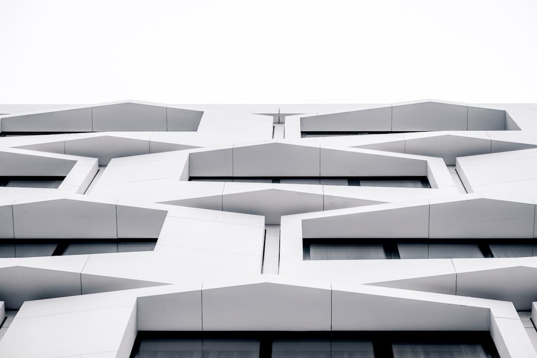 Façade d'un bâtiment blanc aux formes géométriques en zigzag, illustrant la complexité maîtrisée d'un projet web bien conçu