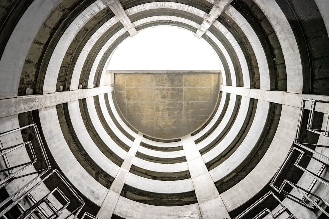 Architecture circulaire monochrome lyonnaise vue en contre-plongée, illustrant les fondations d'une stratégie SEO locale solide