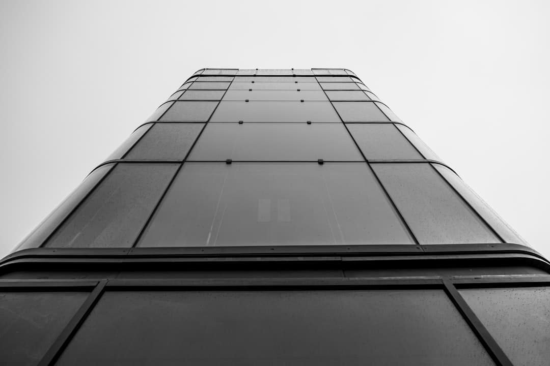 Façade en verre d'un immeuble moderne photographié en contre-plongée, en noir et blanc