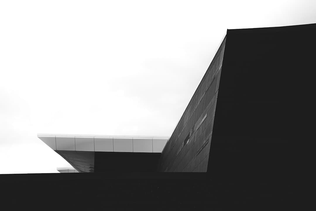 Architecture moderne en niveaux de gris contrastant noir et blanc, métaphore des deux approches Next.js et WordPress